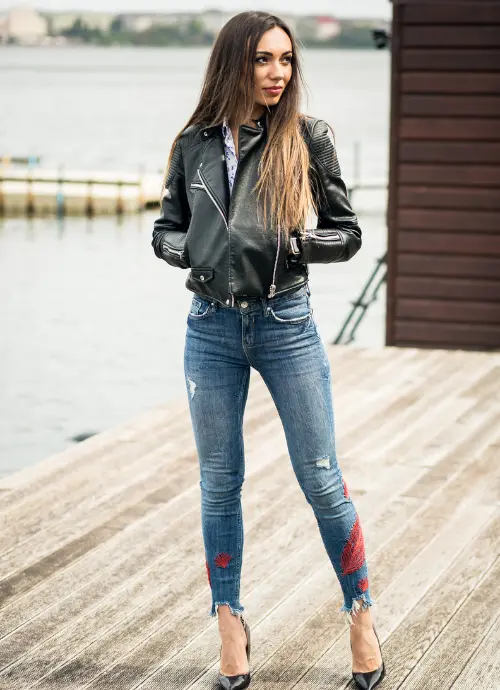A Young Lady Wearing Oversized Shirt With Leather Jacket, Jeans And Heels