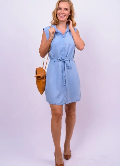 A Stylish Women Wearing Oversized Dress Shirt With Sandals And Holding A Handbag