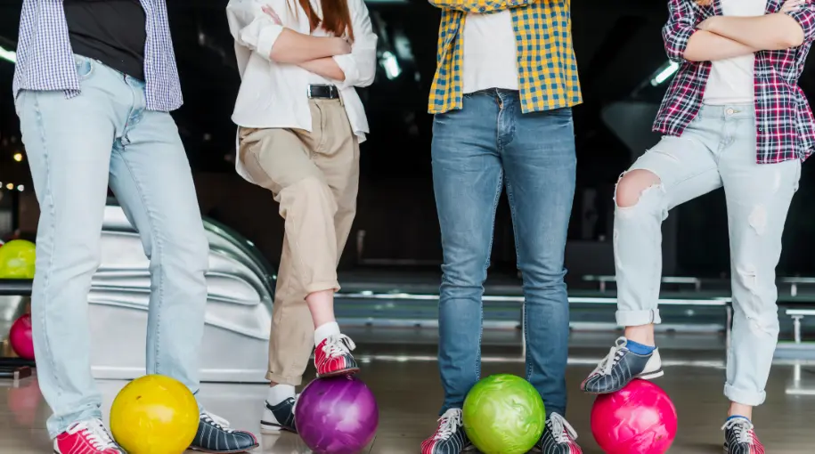 Women Wearing Bowling Attire And Holding Ball Under Their Feet
