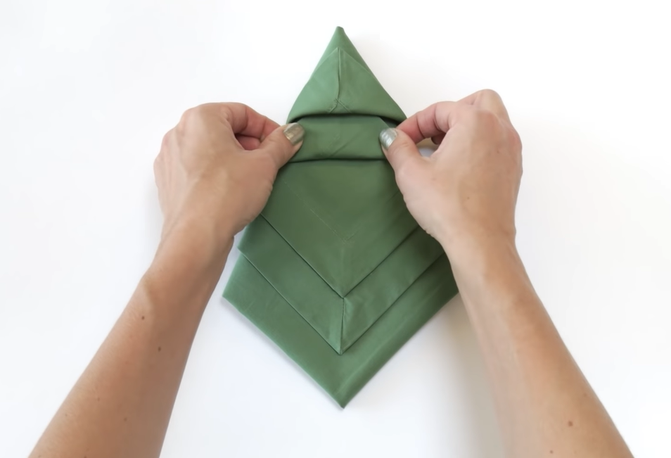 A Green Colored Napkin Folded In Christmas Tree Shape