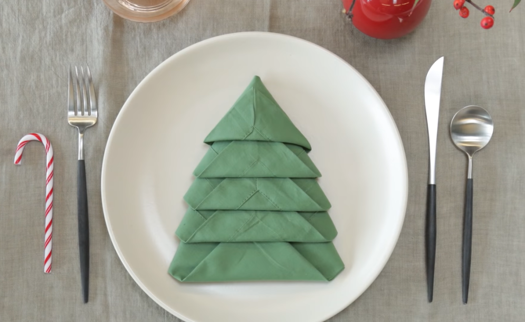A Green Colored Napkin Folded In Christmas Tree Shape